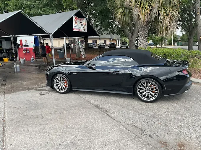 Black Ford Mustang convertible at AJS Auto Spa canopy