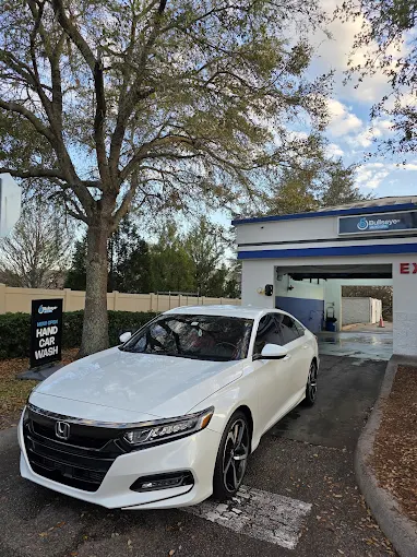 White Honda near Bullseye Auto Spa hand car wash sign