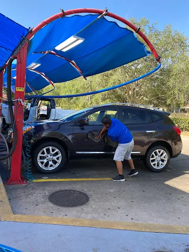Black SUV being hand dried at DLuxe Hand Car Wash in Orlando