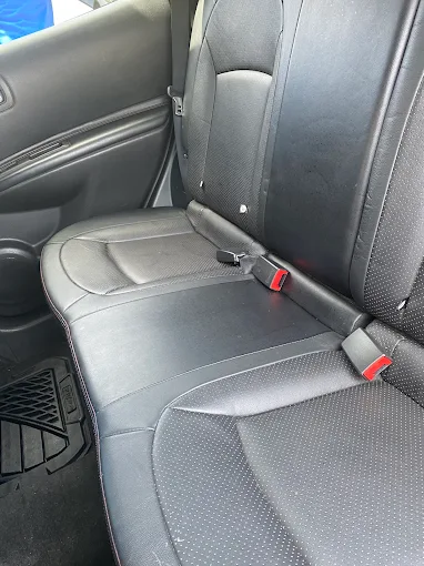 Clean black leather back seat after interior detailing at DLuxe Hand Car Wash