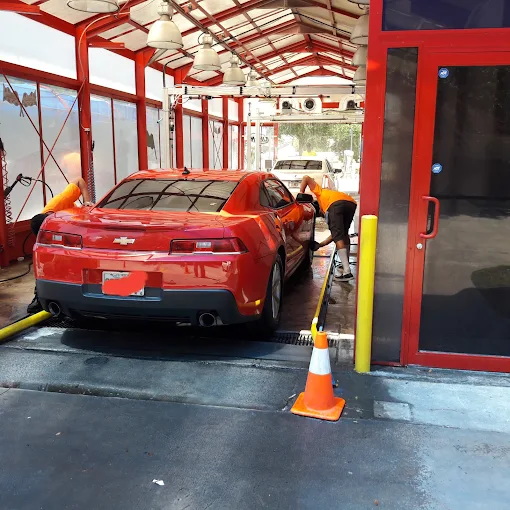 Red Chevrolet Camaro being hand washed inside DLuxe Hand Car Wash bay