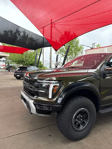 Dark Ford truck under red and black canopy at Images Auto Spa in Orlando