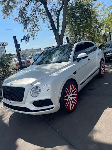 White Bentley SUV with red wheels after service at Images Auto Spa
