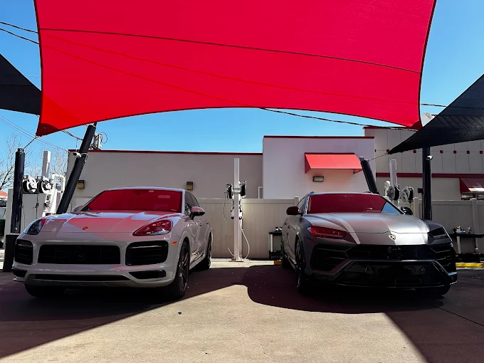 Porsche SUV and Lamborghini SUV under red canopy at Images Auto Spa