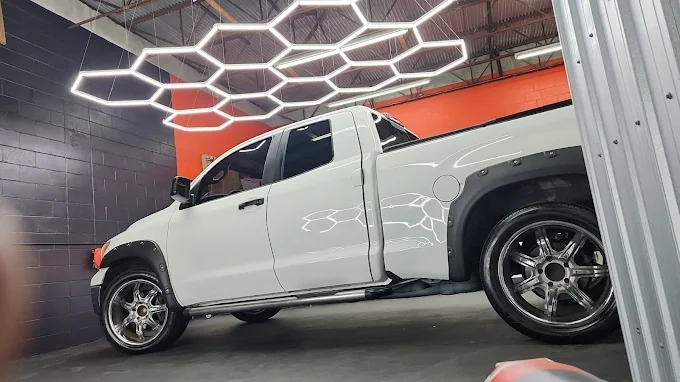 White pickup truck inside Images Auto Spa detailing bay with hex lights