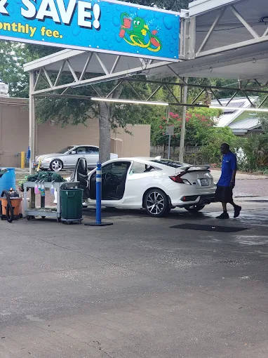 White sedan in vacuum and full-service lane at Octopus Car Wash